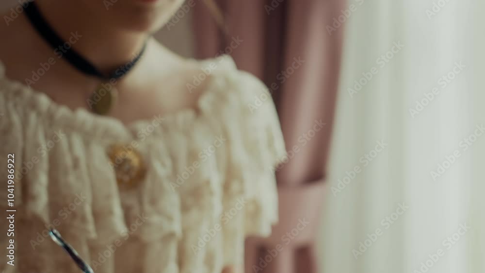 Tilt up closeup shot of Victorian woman in vintage lace dress writing letter with ink pen in bright room with classical decor