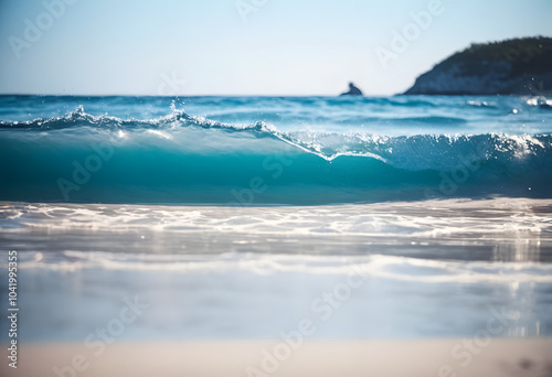 On the shore there is white sand, waves with clear blue water