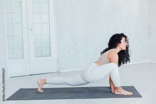 Relaxe harmonious beautiful brunette woman yoga instructor standing in anjaneyasana pose, photo