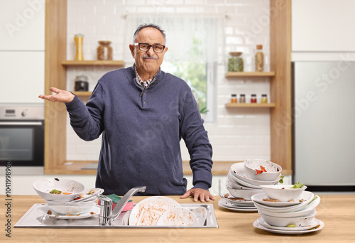 Angry mature man with a pile of dirty dishes