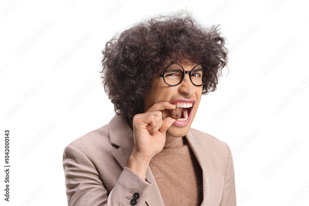 Young man trying to crack a walnut with his teeth