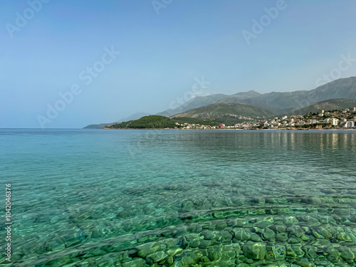 Panoramic view of the picturesque coastline of coastal tourist town Himare, Vlore, Albania. Turquoise water of Ionian Mediterranean sea seen from beach Potami. Vistas of majestic Ceraunian mountains photo