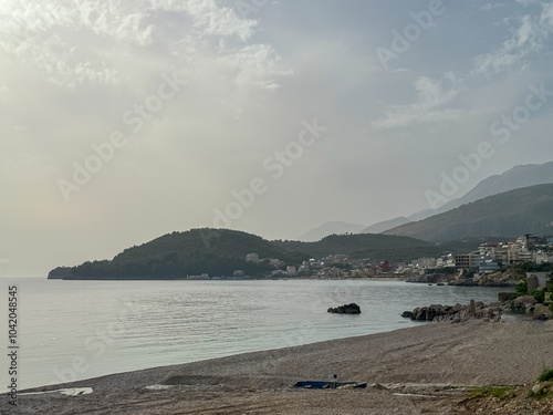 Panoramic view of the picturesque coastline of coastal tourist town Himare, Vlore, Albania. Idyllic sand beach Potami with scenic vistas of majestic Ceraunian mountains. Summer vacation concept photo