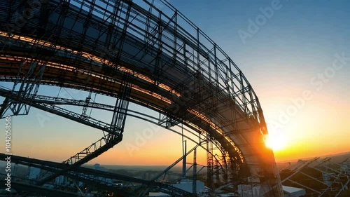 Steel Silhouette at Sunset: A captivating silhouette of a large, industrial structure against the vibrant hues of a setting sun. The image evokes a sense of strength, scale, and the passage of time. 