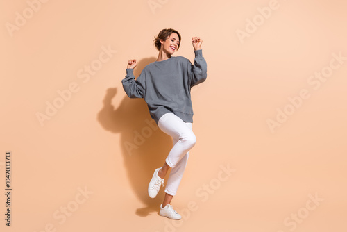 Full size photo of pretty young girl dancing discotheque have fun wear trendy gray outfit isolated on beige color background