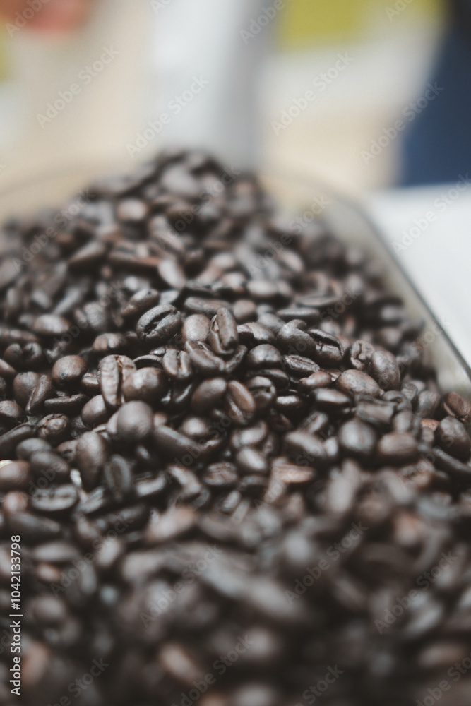 Roasted coffee beans into the coffee machine at home or office in the early morning Roasted coffee beans into the coffee machine at home or office in the early morning