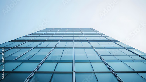 Modern glass office building with reflections windows, in a low angle view, with a white sky background