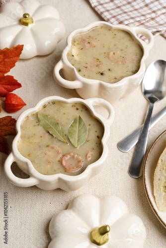 A traditional Polish dish is zhurek, served in beautiful light bowls in the shape of a pumpkin. Thick soup with slices of sausage and decorated with two large bay leaves. photo