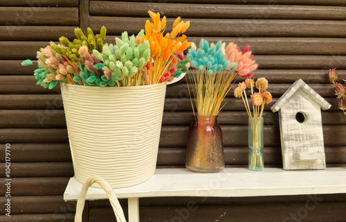 Colourful dried flowers on a plate, dried flowers such as lagurus, beach lilac, millet, craspedia, pampas grass, phalaris and strawflowers photo