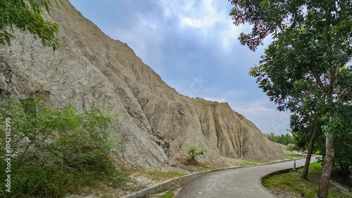 Scenic rocky hill with winding path and greenery.