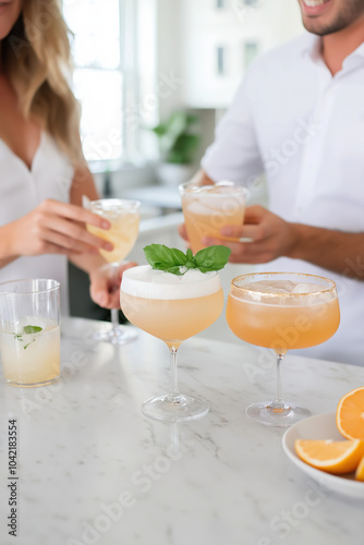 Friends enjoying colorful cocktails at a sunny kitchen gathering in the afternoon