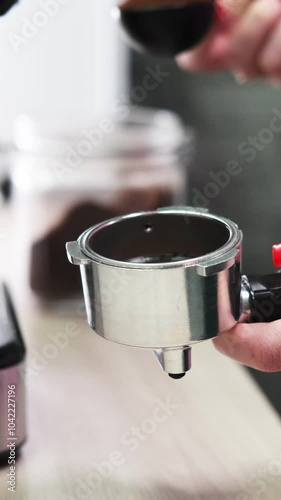 The girl pours coffee into the holder, levels it and presses it with a tamper. Making coffee at home
