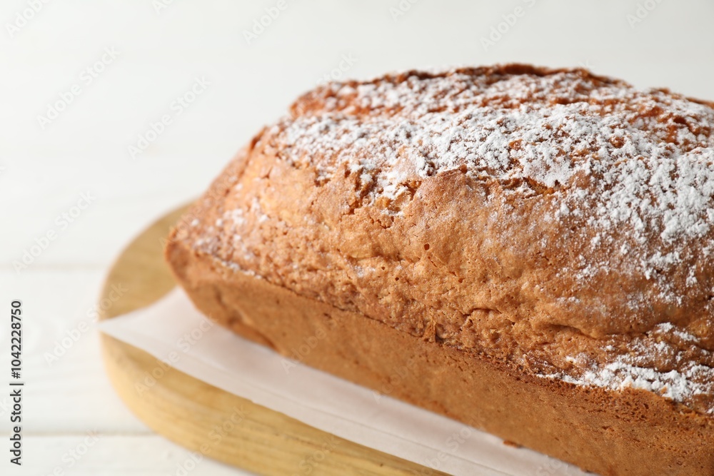 Tasty sponge cake with powdered sugar on white table, closeup Tasty sponge cake with powdered sugar on white table, closeup