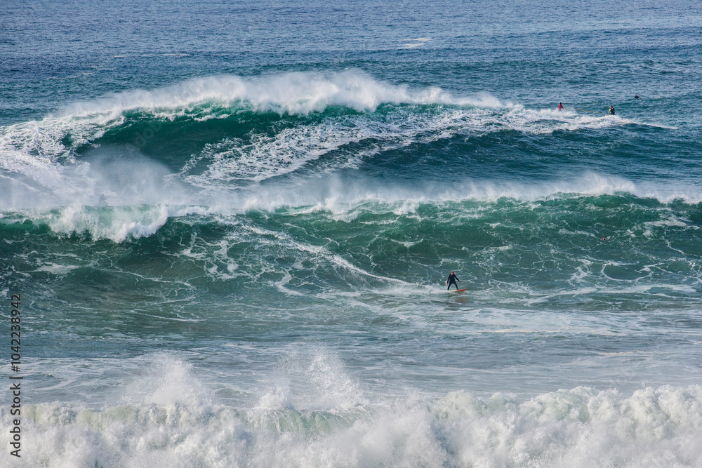 Fototapeta premium Big waves at Nazarè beach in Portugal, photographs of surfers having fun in the Atlantic Ocean