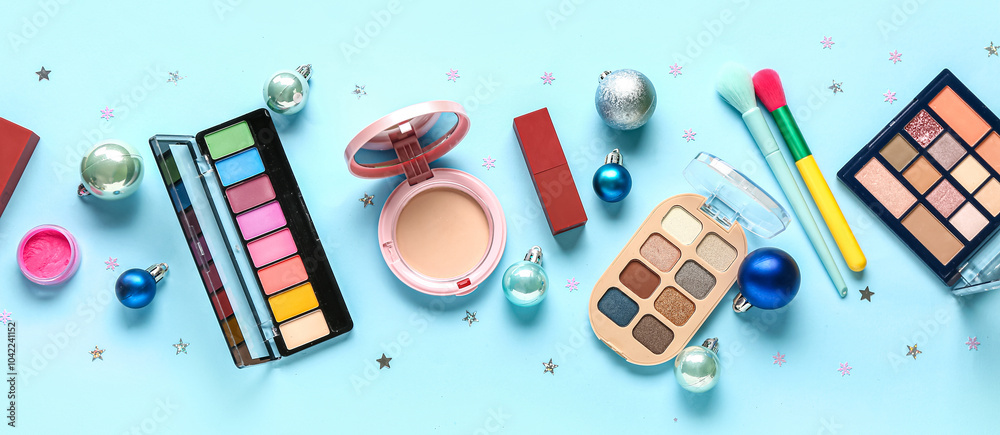 Fototapeta premium Makeup products and Christmas decor on blue background