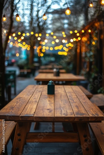 Rustic wooden table with warm lights in a cozy indoor setting during evening ...