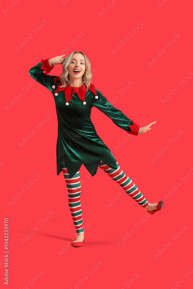 Happy young woman dressed as elf on red background Happy young woman dressed as elf on red background