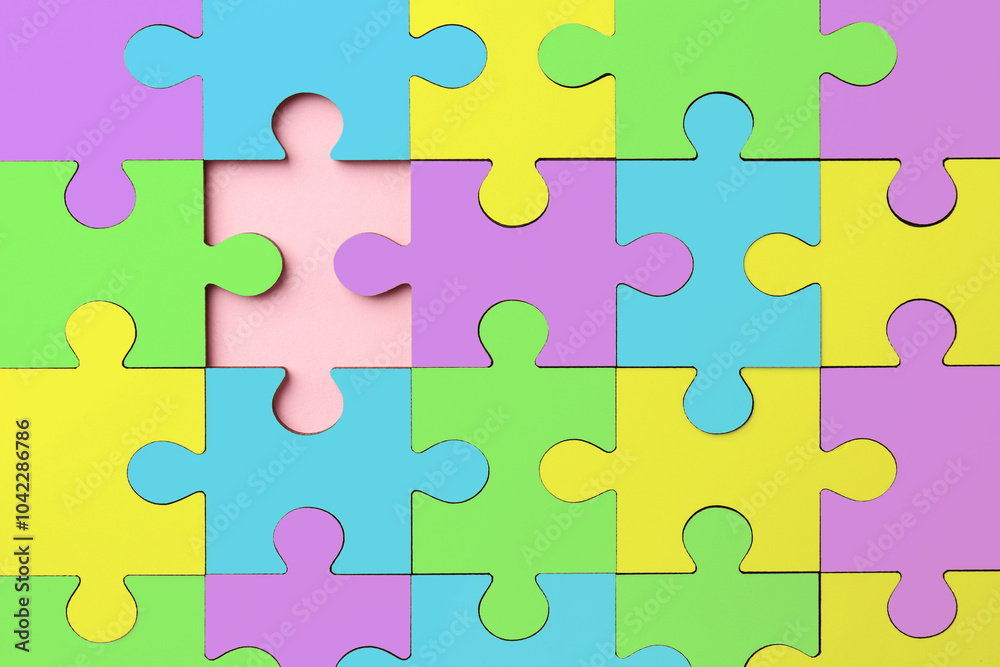 Many colorful puzzle pieces on pink background, top view. Symbol of autism Many colorful puzzle pieces on pink background, top view. Symbol of autism