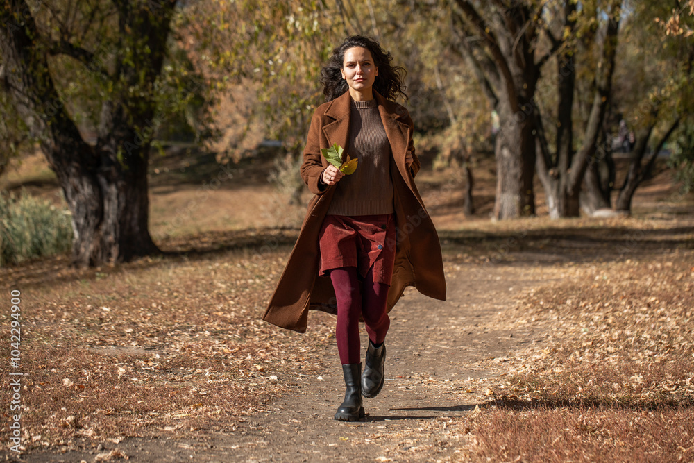 Beautiful middle aged woman walking in autumn park Beautiful middle aged woman walking in autumn park