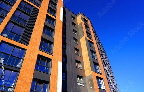 Modern facade building. Facade of high rise urban Modern house. balcony and Windows . Architecture building exterior, house block. High Rise house. Residential development in UK. City built. Blue sky.