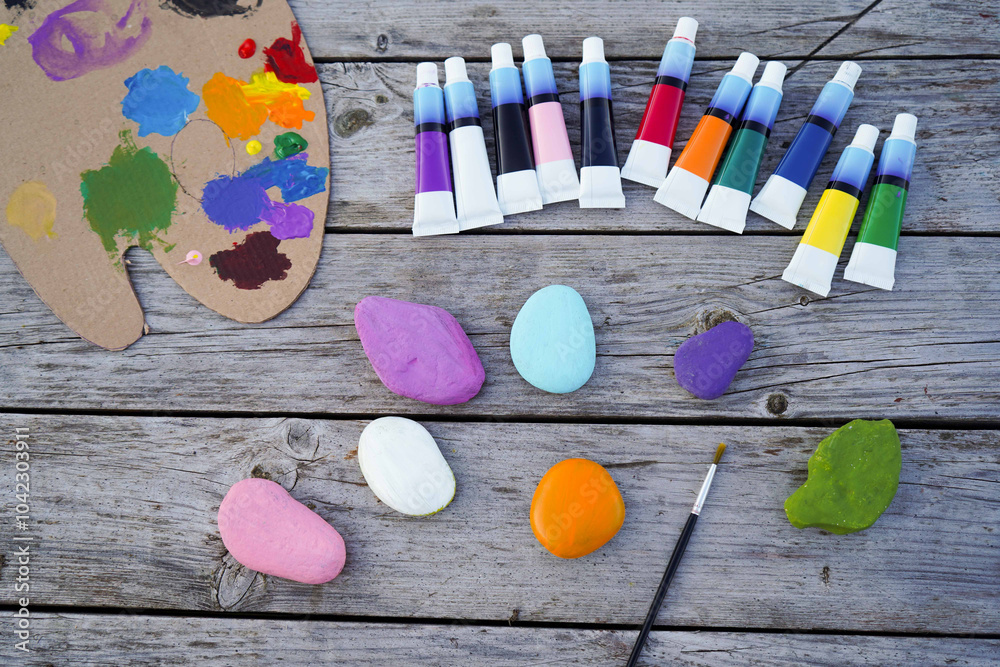 Flat stones painted with acrylic paints. Do it yourself. Souvenirs that children can make.