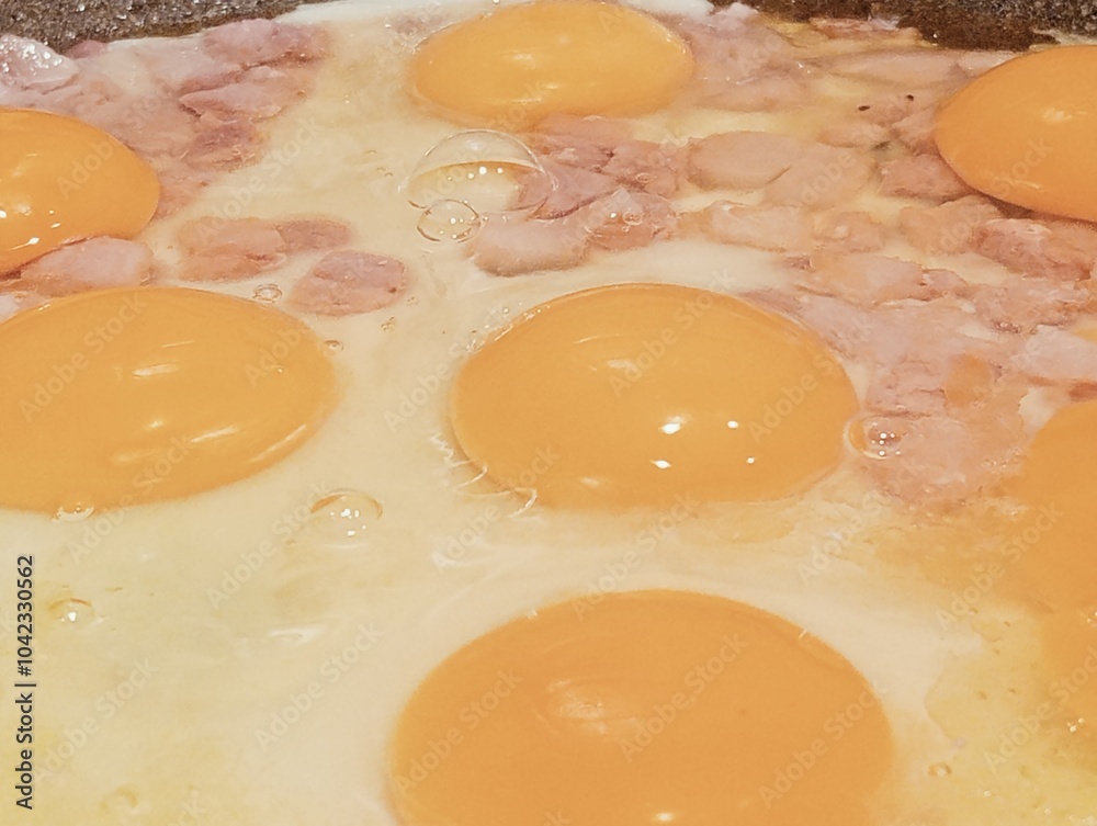 fried eggs with ham in a frying pan