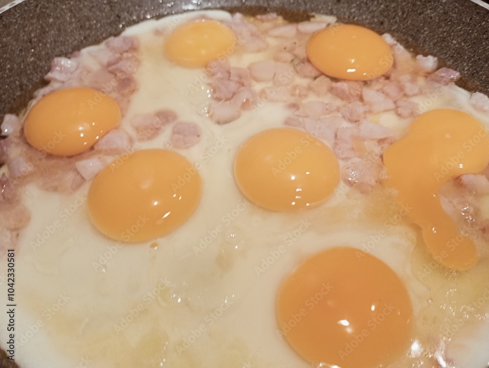 fried eggs with ham in a frying pan