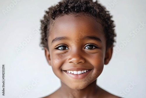 African child boy with short curly hair and dark skin, smiling on a white background 5