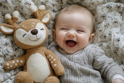 Baby with deer plush toy, lying on a blanket, natural light, laughing, top-down angle 1 photo