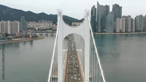 BUSAN, SOUTH KOREA - OCTOBER 19, 2024: Busy traffic crosses the stunning Gwangandaegyo bridge with city skyline in the background photo