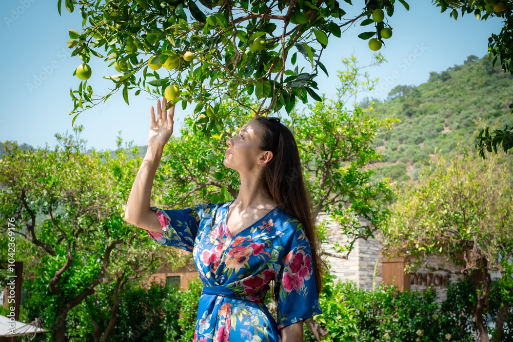 A woman peacefully walking between vibrant lemon trees, enjoying the fresh, natural surroundings, creating a calm and serene atmosphere in a garden. A woman peacefully walking between vibrant lemon trees, enjoying the fresh, natural surroundings, creating a calm and serene atmosphere in a garden.