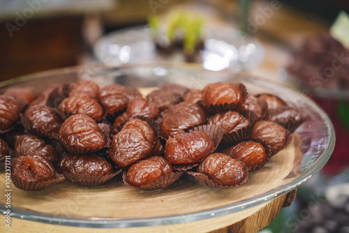 A tray of delicious marron glacés, each delicately glazed chestnut offers a luxurious blend of sweet indulgence and seasonal elegance. photo