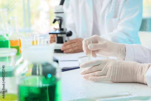 Female chemist working at table in laboratory, closeup