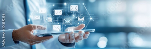 Businessman using digital tablet displaying email icons, illustrating modern communication and technology in business environments.