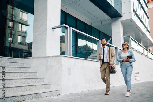 Business people walking and talking about work outside office building