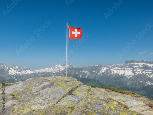 Fotografie Schweizer Fahne flattert auf dem Berggipfel im Wind