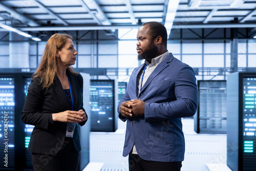 Team of engineers doing disaster recovery planning and security protocol enforcement in data center. Teamworking colleagues in server room reducing downtime, ensuring business continuity