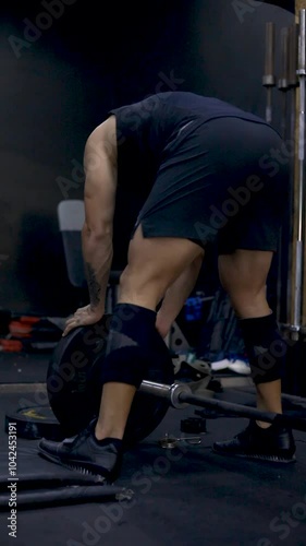 man putting weights on the bar