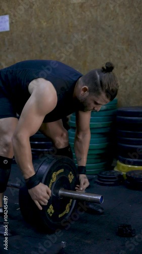 man putting weights on the bar