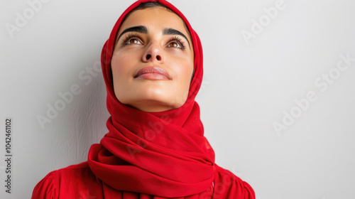 A young woman in traditional Arabic attire gazes upward, exuding beauty and elegance in her cultural expression.