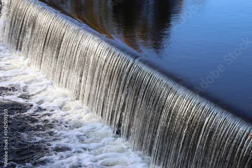 A beautiful background with a waterfall and a mirror effect of the water. Water preservation and cascades. discharge of a river in autumn. Environment and the renewable. Wendake river in Quebec.
