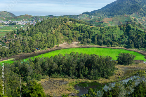 Morning view of Telaga Warna Lake with mountain background at Dieng Plateau, Central Java, Indonesia. Aerial View from Batu Pandang Ratapan Angin Hill photo