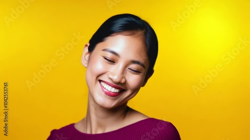 Portrait of a happy smiling young Asian woman over yellow background. A perfect blend of style and substance, she navigates her career with grace against a lively pink background. 24 fps FHD video. photo