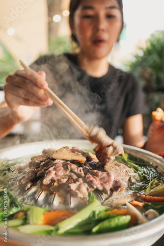 Happy asian woman enjoy her delicious Thai BBQ Buffet. photo