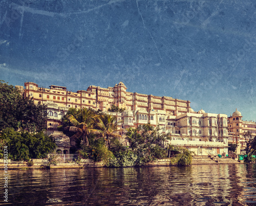 Vintage retro hipster style travel image of India luxury tourism concept background - Udaipur City Palace from Lake Pichola with grunge texture overlaid. Udaipur, Rajasthan, India photo