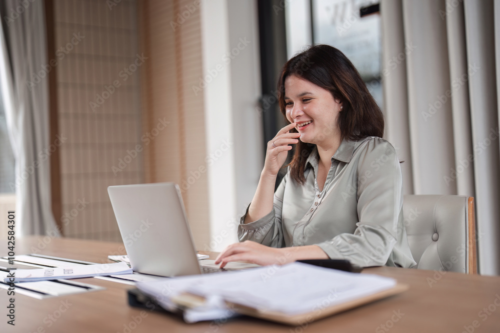 Young Businesswoman Analyzing Documents at Her Desk in a Modern Office Setting Young Businesswoman Analyzing Documents at Her Desk in a Modern Office Setting