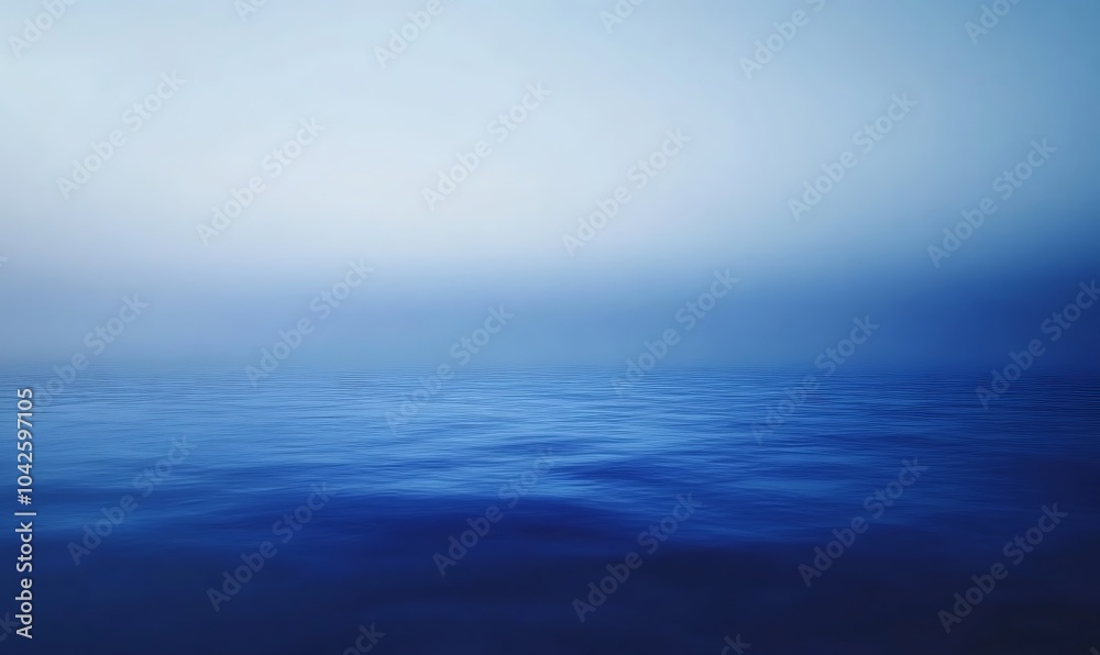Fototapeta premium A serene, blue seascape with calm waters blending into a soft, hazy horizon, evoking a sense of tranquility and vastness.