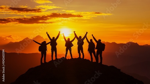 Team Members Helping Each Other Reach the Summit in a Golden Sunset Silhouette