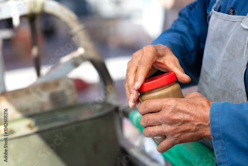 A vendor selling sesame paste is beating sesame paste photo