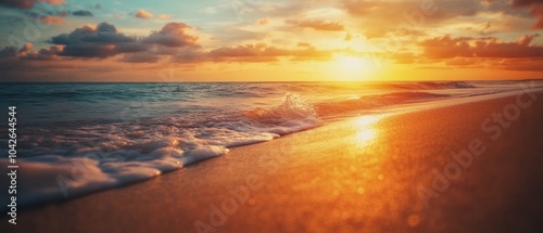 A serene sunset over the ocean, with gentle waves lapping against the sandy shore.